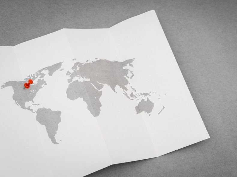 Paper folded world map  with red Pin Pointer